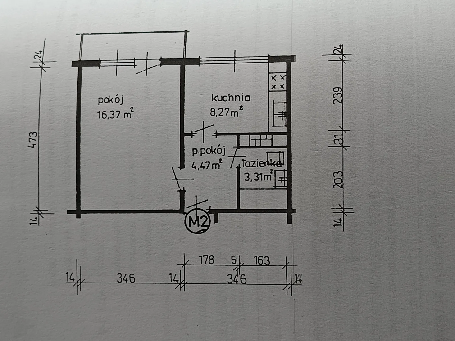 Ręcznie narysowany rzut mieszkania z podziałem na pomieszczenia i wymiarami. Po lewej stronie znajduje się 'pokój' o powierzchni 16,37 m². Po prawej stronie znajduje się 'kuchnia' o powierzchni 8,27 m², mniejszy 'p.pokój' o powierzchni 4,47 m² oraz 'łazienka' o powierzchni 3,31 m². Na planie naniesione są wymiary ścian: pionowe po lewej stronie (24, 473, 14) i po prawej (24, 239, 31, 203, 14), oraz poziome na dole (14, 346, 14, 178, 5, 163, 346, 24). W dolnej części planu widnieje oznaczenie 'M2' w kółku.