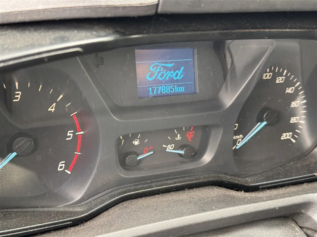 Zbliżenie na deskę rozdzielczą samochodu marki Ford. W centralnej części znajduje się cyfrowy wyświetlacz z logo 'Ford' oraz przebiegiem '177885km'. Po lewej stronie widoczny jest obrotomierz z cyframi 3, 4, 5, 6. Po prawej stronie znajduje się prędkościomierz z podziałką do 200 km/h. Pomiędzy nimi umieszczone są wskaźniki poziomu paliwa oraz temperatury silnika, z której drugi wskazuje 120°C.