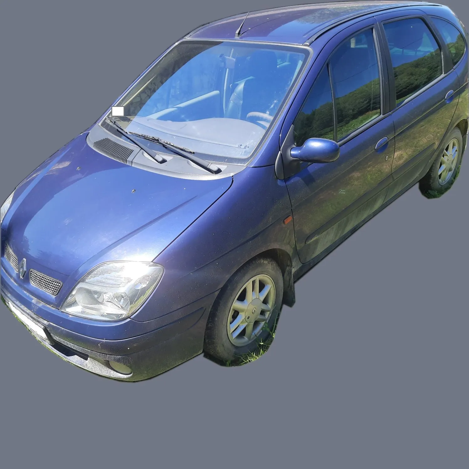 Niebieski samochód typu minivan zaparkowany na trawie, widok z przodu i z boku pod kątem.