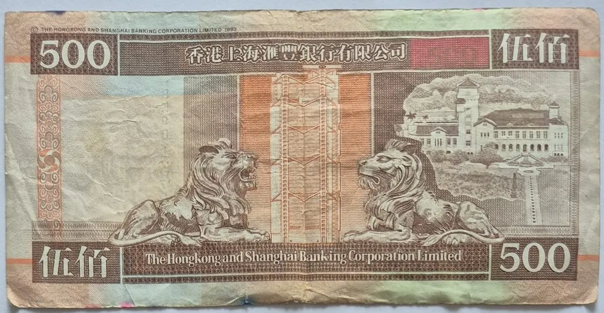 Banknot o nominale 500 z napisem 'The Hongkong and Shanghai Banking Corporation Limited'. Na awersie znajdują się dwa lewy zwrócone ku sobie, w centrum geometryczny wzór przypominający wieżowiec, a po prawej stronie budynek z wieżą. W górnej i dolnej części widnieją liczby '500' oraz chińskie znaki '伍佰'.