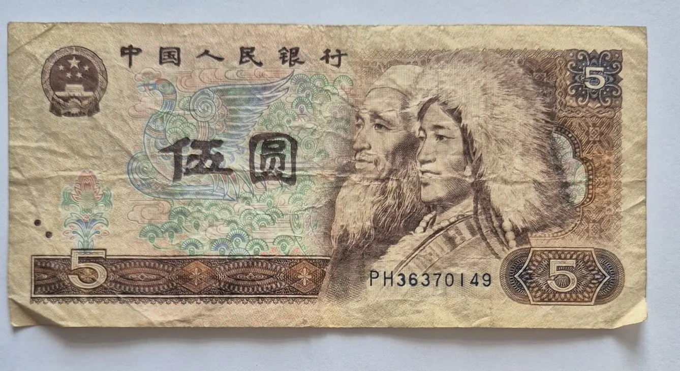Chiński banknot o nominale 5 juanów. Na banknocie widnieją portrety dwóch osób w tradycyjnych nakryciach głowy, w tym jedna osoba w dużym, futrzanym kapeluszu. W górnej części znajduje się napis w języku chińskim: 中国人民银行. W centrum widnieje duży napis 伍圆. W lewym górnym rogu znajduje się godło Chin. W prawym górnym oraz prawym dolnym rogu widoczna jest cyfra 5. W dolnej części znajduje się numer seryjny PH36370149 oraz nominał 5 w lewym dolnym rogu.