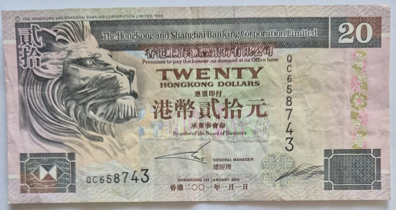 Banknot o nominale 20 dolarów Hongkongu wydany przez The Hongkong and Shanghai Banking Corporation Limited. Po lewej stronie znajduje się duży portret lwa w profilu. W górnej części widnieje napis 'The Hongkong and Shanghai Banking Corporation Limited', a poniżej słowo 'TWENTY HONGKONG DOLLARS' oraz odpowiadający mu tekst w języku chińskim. Numer seryjny 'QC658743' pojawia się dwukrotnie: pionowo po prawej stronie oraz poziomo w dolnej części. Na dole widnieje data '1st JANUARY 2001' oraz podpis General Managera.
