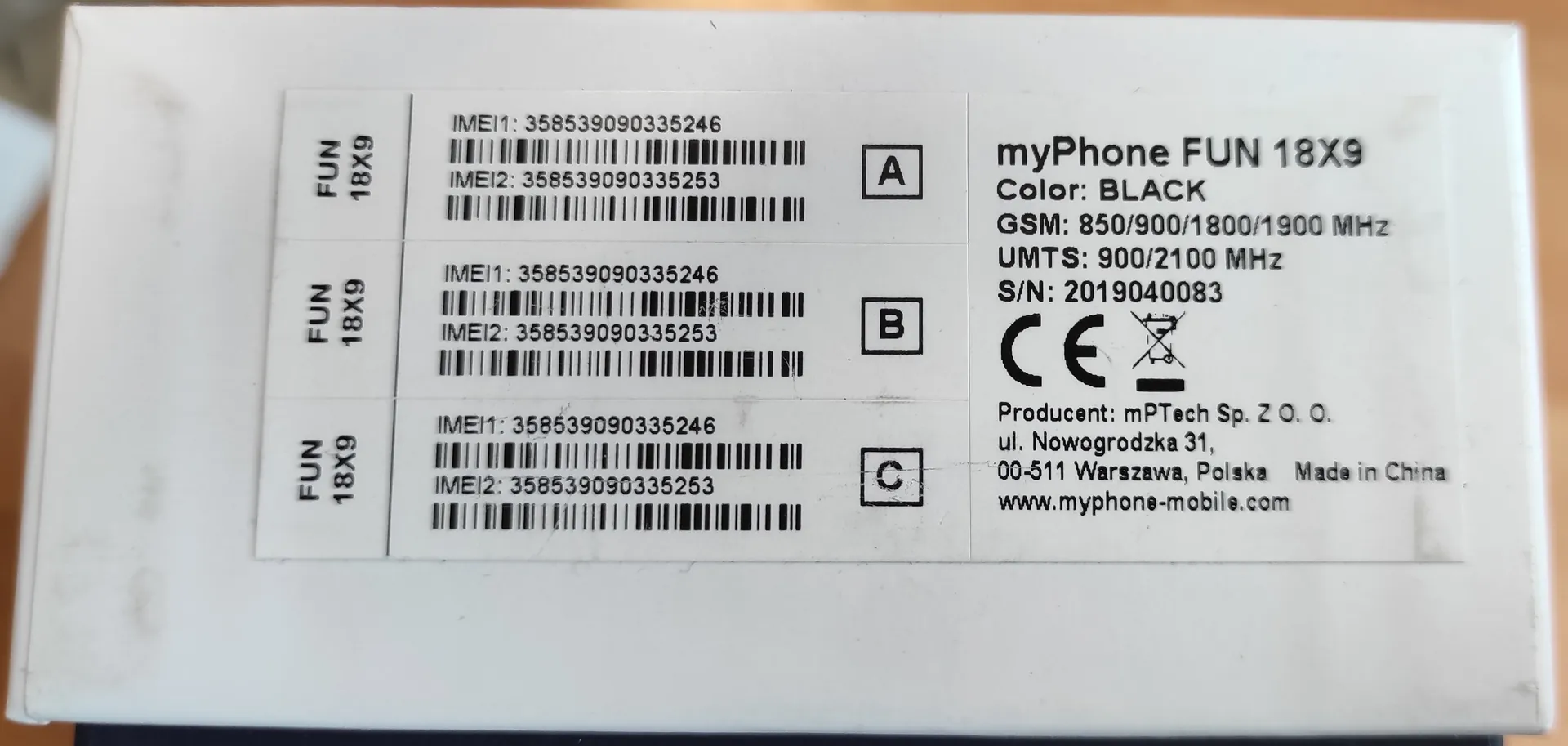 Zdjęcie białego opakowania produktu myPhone FUN 18X9 w kolorze czarnym. Po prawej stronie znajduje się etykieta z informacjami: model 'myPhone FUN 18X9', kolor 'BLACK', częstotliwości GSM (850/900/1800/1900 MHz) i UMTS (900/2100 MHz), numer seryjny 'S/N: 2019040083', znak CE oraz dane producenta: 'mPTech Sp. Z O. O., ul. Nowogrodzka 31, 00-511 Warszawa, Polska', napis 'Made in China' oraz adres strony internetowej 'www.myphone-mobile.com'. Po lewej stronie widnieją trzy identyczne sekcje oznaczone literami A, B i C, z których każda zawiera nazwę modelu 'FUN 18X9', numery IMEI1: 358539090335246 oraz IMEI2: 358539090335253 wraz z odpowiadającymi im kodami kreskowymi.