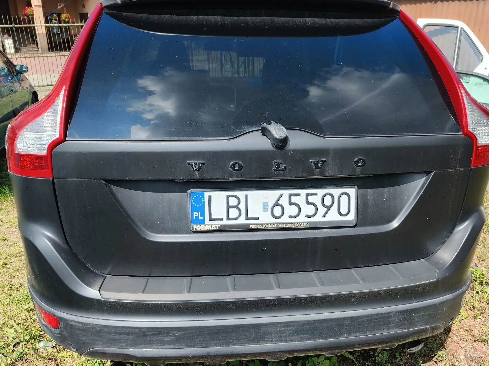 Tylny widok czarnego samochodu marki Volvo. Na klapie bagażnika widnieje napis VOLVO oraz polska tablica rejestracyjna o numerze LBL 65590. Poniżej tablicy znajduje się ramka z napisem FORMAT i hasłem PROFESJONALNE OKLEJANIE POJAZDÓW.