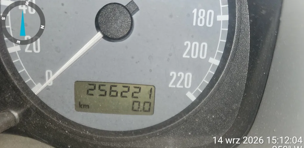 Zbliżenie na licznik pojazdu. Widoczny jest cyfrowy wyświetlacz z przebiegiem 25622,1 km oraz wartością 0.0. W tle znajdują się białe oznaczenia prędkości: 180, 200 i 220. W lewym górnym rogu widoczny jest fragment kompasu. W prawym dolnym rogu znajduje się data i godzina: 14 wrz 2026 15:12:04.