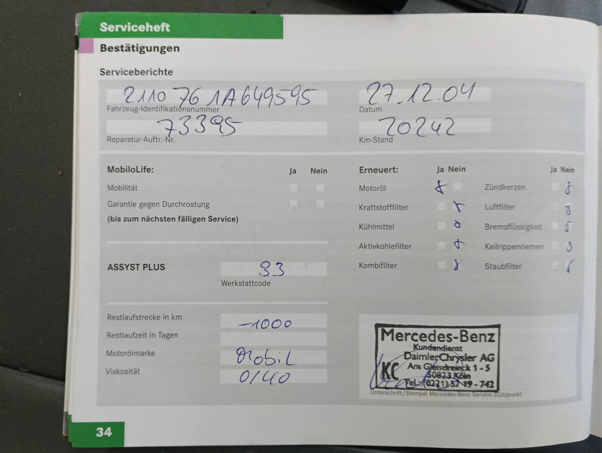 Zdjęcie strony z książki serwisowej pojazdu w języku niemieckim. Na górze widnieje nagłówek 'Serviceheft' oraz sekcja 'Bestätigungen'. Wypełnione odręcznie pola zawierają numer identyfikacyjny pojazdu '2110 76 LA 649595', datę '27.12.04', numer zlecenia naprawy '73395' oraz przebieg '20242' km. Poniżej znajduje się tabela z listą sprawdzonych elementów (np. olej silnikowy, filtry), gdzie zaznaczono opcje 'Ja' (tak) lub 'Nein' (nie). Widnieje również kod warsztatu '83', marka oleju 'Mobil 0W-40' oraz pieczątka z podpisem serwisu Mercedes-Benz z Kolonii (Köln). W lewym dolnym rogu strony znajduje się numer '34'.