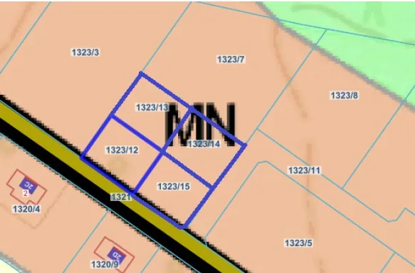 Fragment mapy geodezyjnej z zaznaczonymi działkami. Centralna część obrazu zawiera niebieską ramkę dzielącą obszar na trzy mniejsze działki o numerach 1323/13, 1323/12 oraz 1323/15. Na działkach widnieje duży, czarny napis 'MN'. Wokół znajdują się inne działki z numerami: 1323/3, 1323/7, 1323/8, 1323/11, 1323/5 oraz 1320/4 i 1320/9. Przez obraz przebiega ukośna, czarna droga z żółtymi krawędziami.