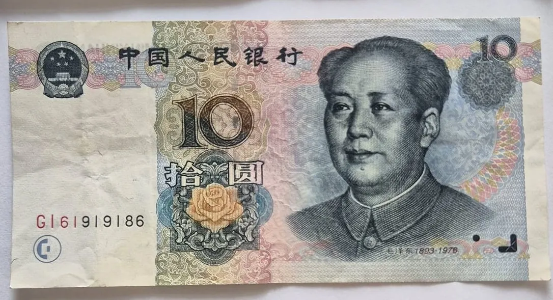Chiński banknot o nominale 10 juanów. Po prawej stronie znajduje się portret Mao Zedonga. Po lewej stronie widnieje godło Chińskiej Republiki Ludowej oraz numer seryjny G161919186. Na górze znajduje się napis w języku chińskim: 中国人民银行. W centrum widoczna jest liczba 10 oraz chińskie znaki 拾圆. Banknot ma kolorystykę beżową, różową i niebieską z ozdobnymi giloszami i motywem kwiatu róży na dole.