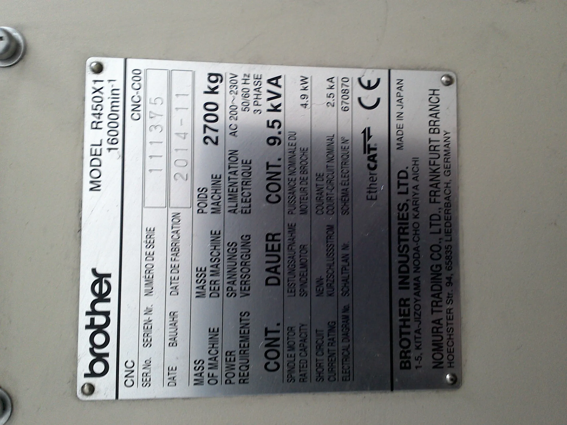 Tabliczka identyfikacyjna maszyny marki brother. MODEL R450X1 16000min⁻¹, CNC-C00. Numer seryjny: 111375. Data produkcji: 2014-11. Masa maszyny: 2700 kg. Wymagania zasilania: AC 200~230V 50/60 Hz 3 PHASE. Moc ciągła: 9.5 kVA. Moc silnika wrzeciona: 4.9 kW. Znamionowy prąd zwarcia: 2.5 kA. Numer schematu elektrycznego: 670870. Oznaczenia: EtherCAT, CE. Producent: BROTHER INDUSTRIES, LTD. MADE IN JAPAN, 1-5, KITA-JIZOYAMA NODA-CHO KARIYA AICHI. Diler: NOMURA TRADING CO., LTD., FRANKFURT BRANCH, HOECHSTER Str. 94, 65835 LIEDERBACH, GERMANY.