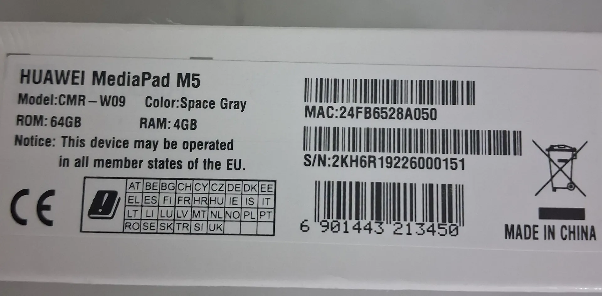Etykieta produktu Huawei MediaPad M5 w kolorze Space Gray. Widoczne specyfikacje: Model: CMR-W09, ROM: 64GB, RAM: 4GB. Tekst informacyjny: 'Notice: This device may be operated in all member states of the EU'. Na etykiecie znajdują się dwa kody kreskowe z numerami MAC: 24FB6528A050 oraz S/N: 2KH6R19226000151, a także trzeci kod kreskowy z numerem 6 901443 213450. Widoczne są znaki certyfikacji CE, piktogram przekreślonego kosza oraz tabela z kodami krajów UE. W prawym dolnym rogu znajduje się napis 'MADE IN CHINA'.
