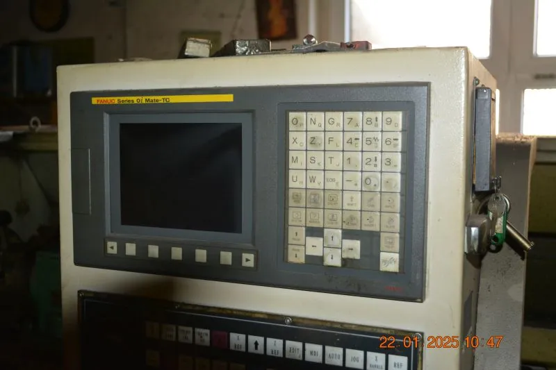 Panel sterowania maszyny CNC marki FANUC, model Series 0i Mate-TC. Urządzenie posiada ekran wyświetlacza po lewej stronie, pod którym znajduje się rząd przycisków funkcyjnych, oraz klawiaturę alfanumeryczną po prawej stronie. Obudowa jest w kolorze kremowym. W prawym dolnym rogu zdjęcia widoczna jest data i godzina: 22.01.2025 10:47.