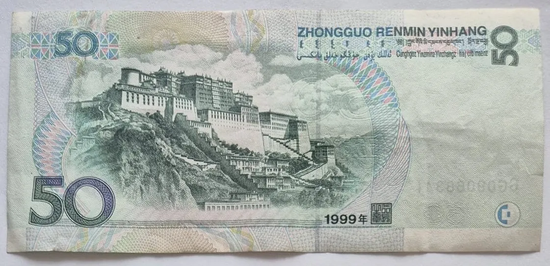 Rewers chińskiego banknotu o nominale 50 juanów z 1999 roku. Na banknocie widnieje szczegółowy rysunek Pałacu Potala w Lhasie, położonego na wzgórzu. W prawym górnym rogu znajduje się napis 'ZHONGGUO RENMIN YINHANG' oraz tekst w innych językach. W lewym górnym i lewym dolnym rogu widoczna jest liczba '50'. W prawym dolnym rogu znajduje się data '1999年' oraz pieczęć. Tło banknotu jest jasne z delikatnymi, kolorowymi wzorami geometrycznymi.
