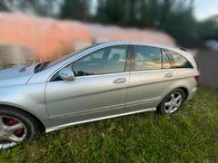Srebrny samochód osobowy typu kombi zaparkowany na trawie, widok z boku.