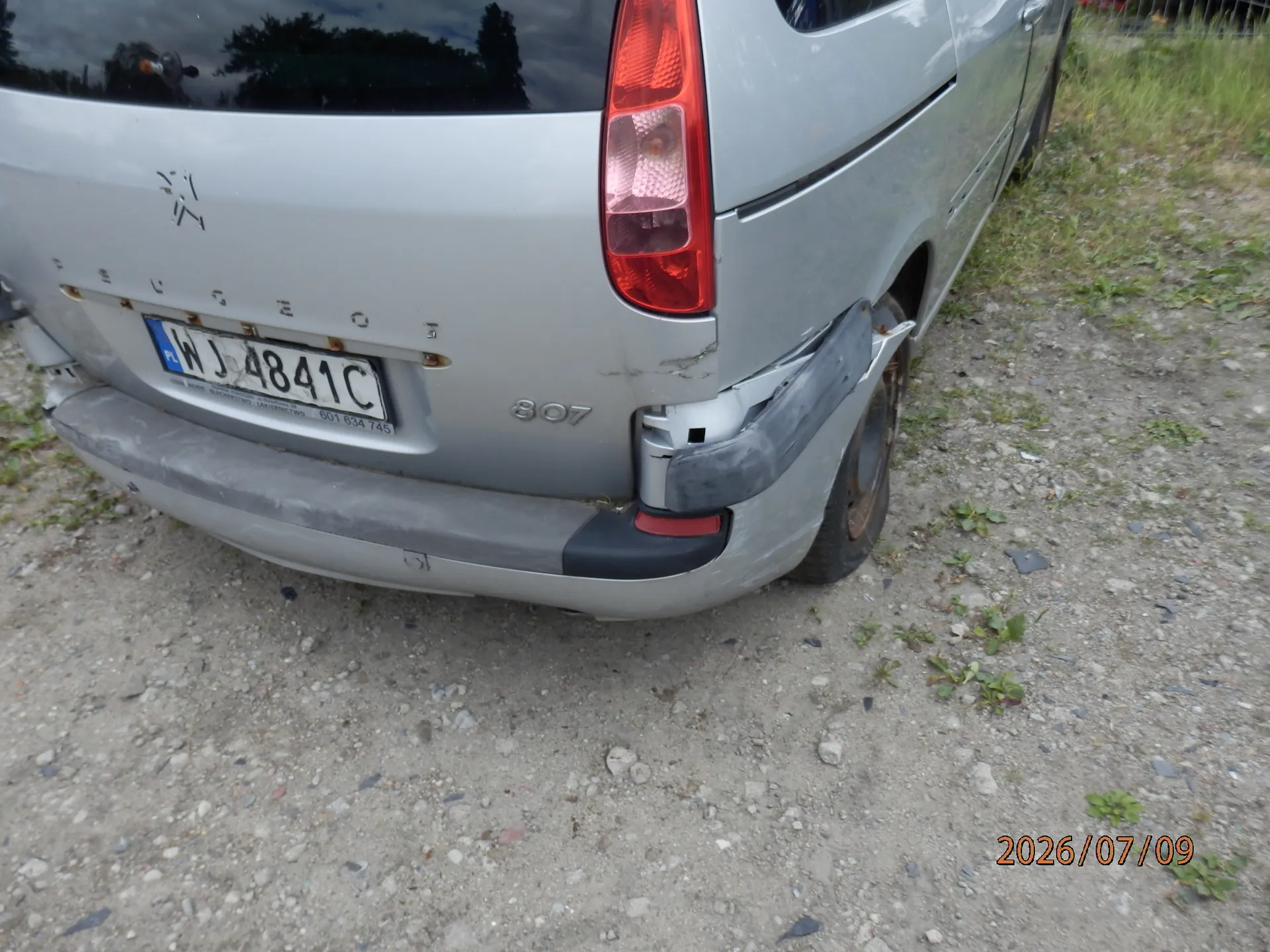 Tylna część srebrnego samochodu marki Peugeot 807 z widocznymi uszkodzeniami prawego tylnego zderzaka i błotnika. Samochód posiada polską tablicę rejestracyjną o numerze WJ 4841C. W prawym dolnym rogu zdjęcia znajduje się data 2026/07/09.