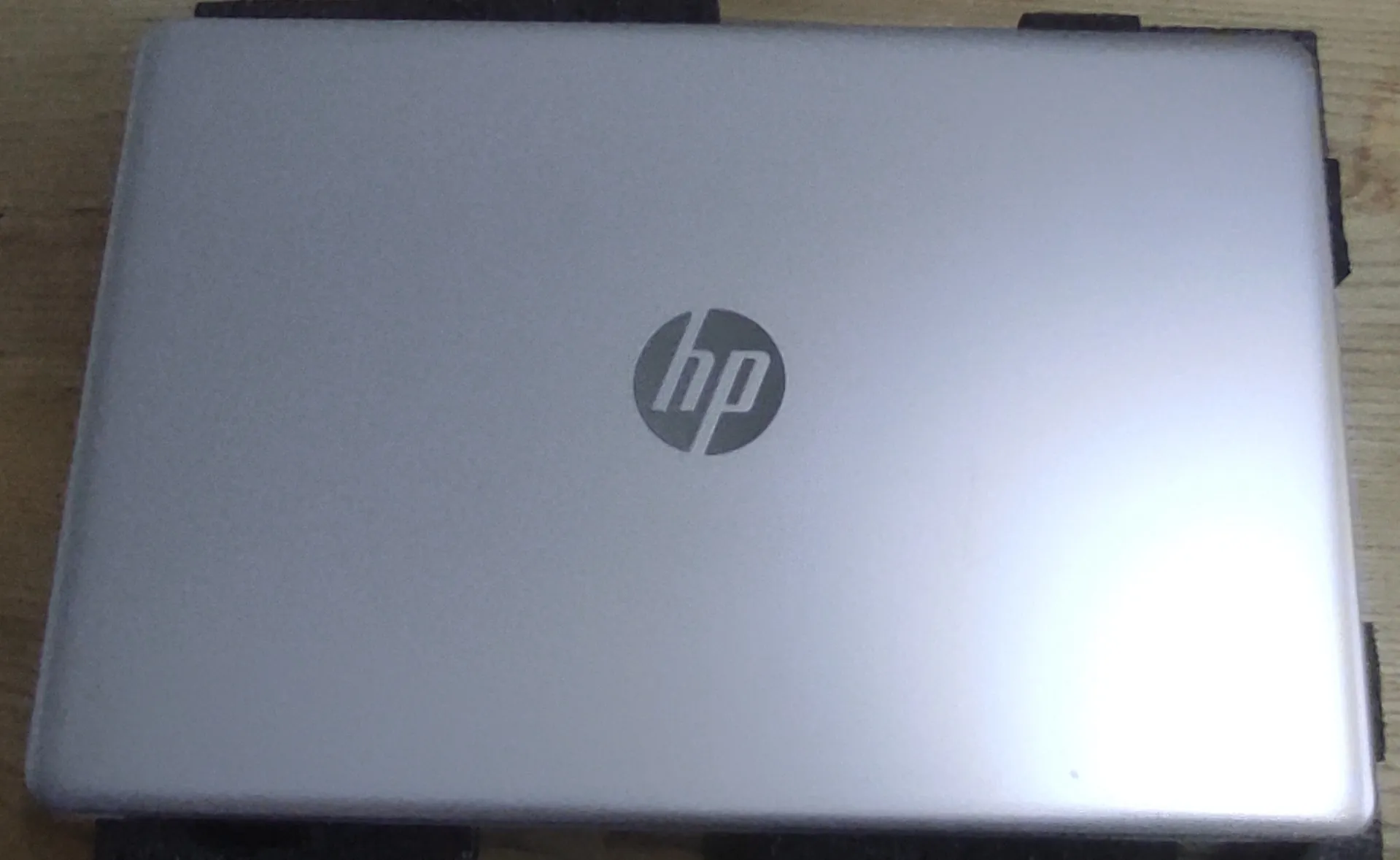 Zamknięty laptop marki HP w kolorze srebrnym, widoczna górna pokrywa z logo HP na środku.