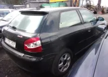 Czarny samochód osobowy typu hatchback zaparkowany na placu. Widok z tyłu i z boku. Pojazd posiada spojler nad tylną szybą oraz tablicę rejestracyjną o numerze 41 GB 5009.